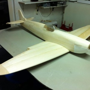 het moeilijkste gedeelte zit erop de romp maken.
Grofweg beschreven je lijmt platen op de box constructie.
Deze maak je nat met een plantenspuit en je taped het om de formers(rompribben) heen.
een weekje laten drogen daarna schuren en schaven tot je er gek van wordt.